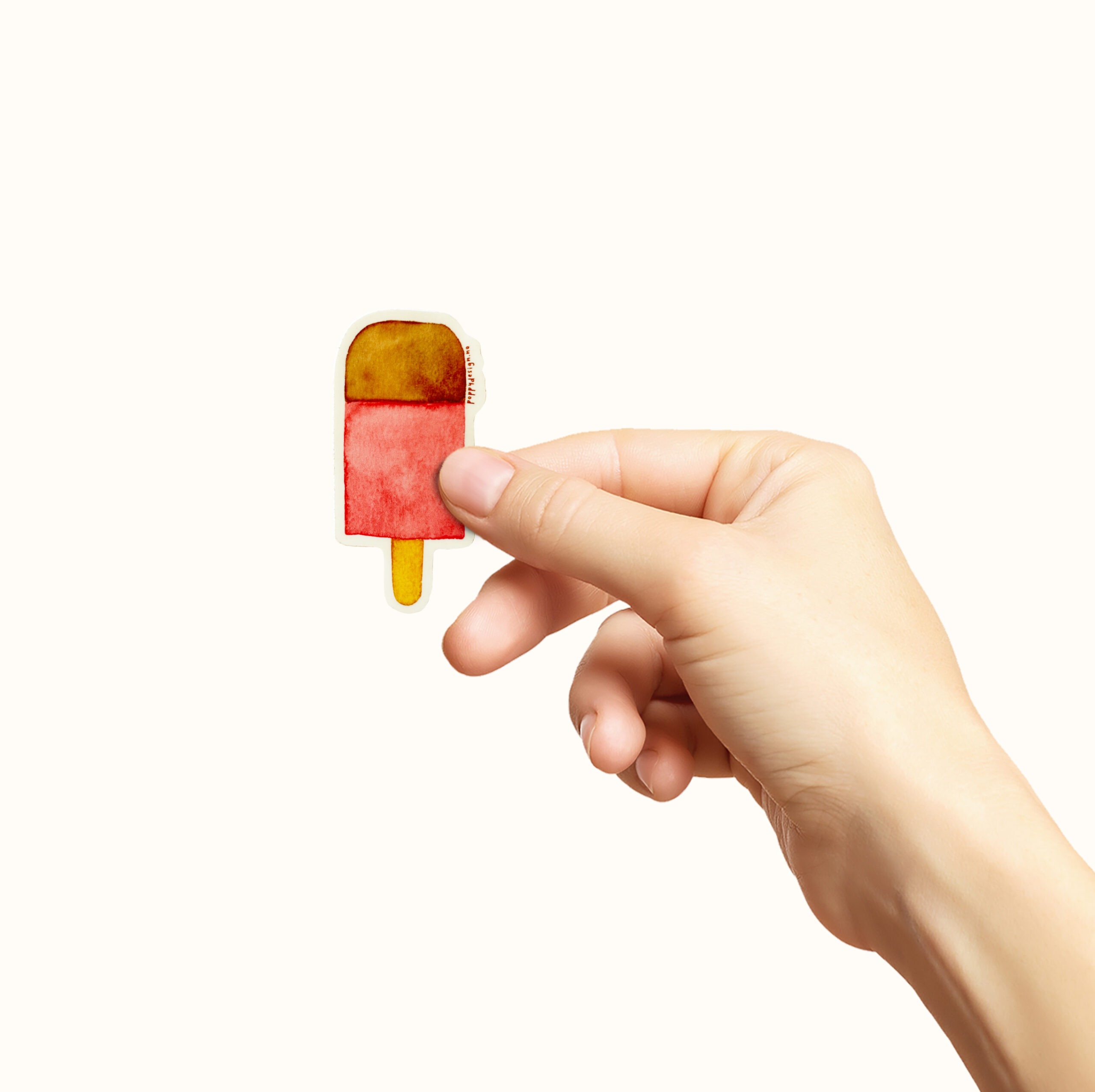 Hånd som holder et klistremerke med en rosa is