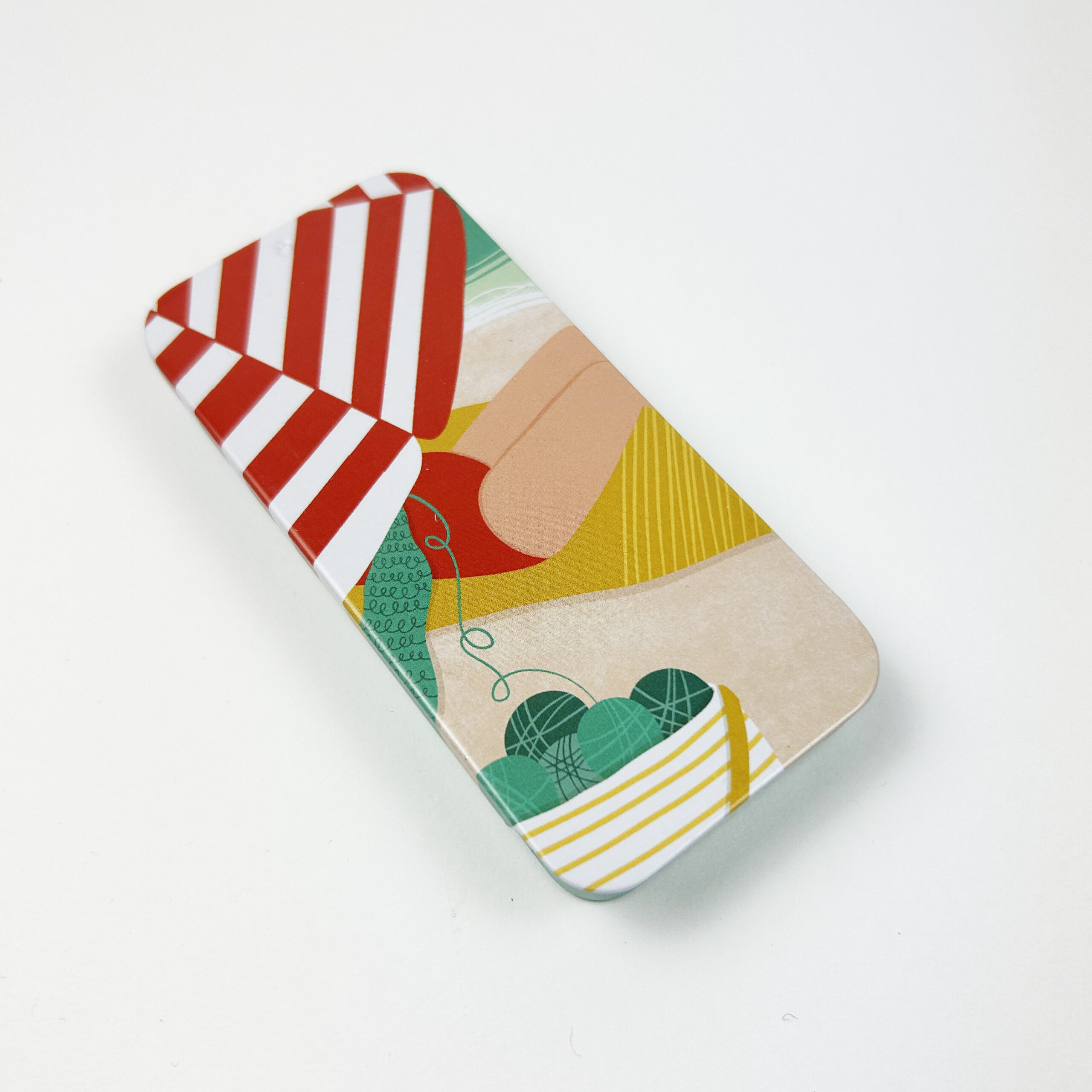 Metallboks med en dame som strikker under en parasoll