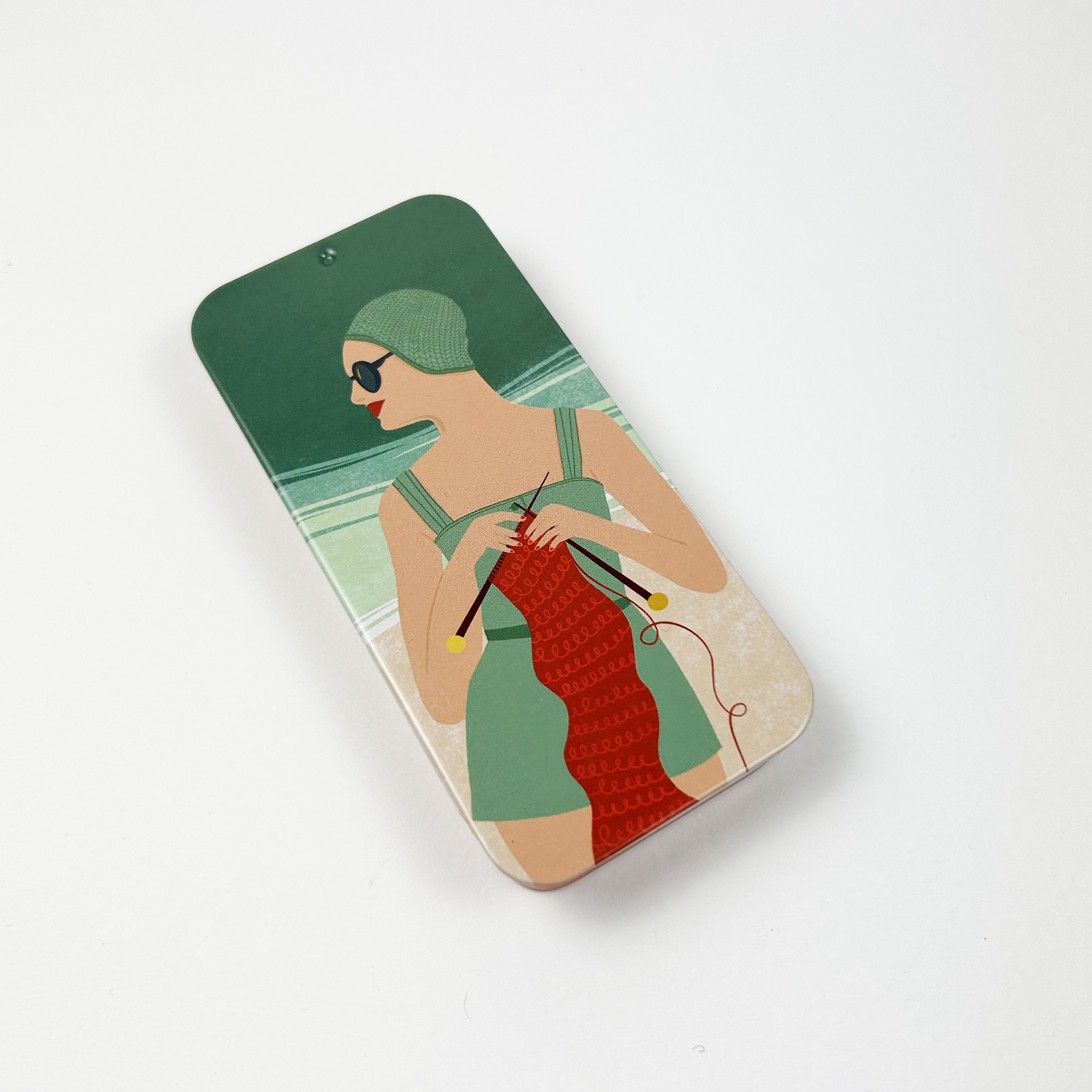 Metallboks med Retro dame som strikekr på stranden