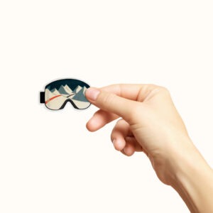 Hånd som holder et klistremerke med skibriller